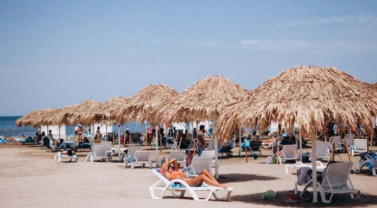 Пляж Sea Breeze: ряды соломенных зонтов и шезлонгов на песке у самой воды